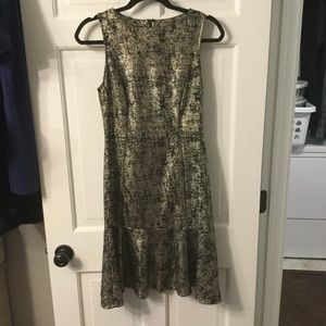 Midi length fitted black and gold cocktail dress.